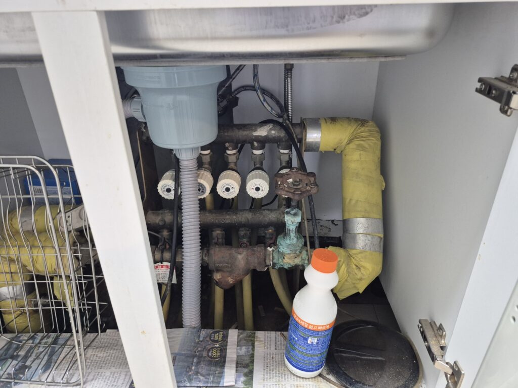 동탄 반송동 싱크대 하부장 내부 배관과 밸브 연결 부위를 확인하는 모습